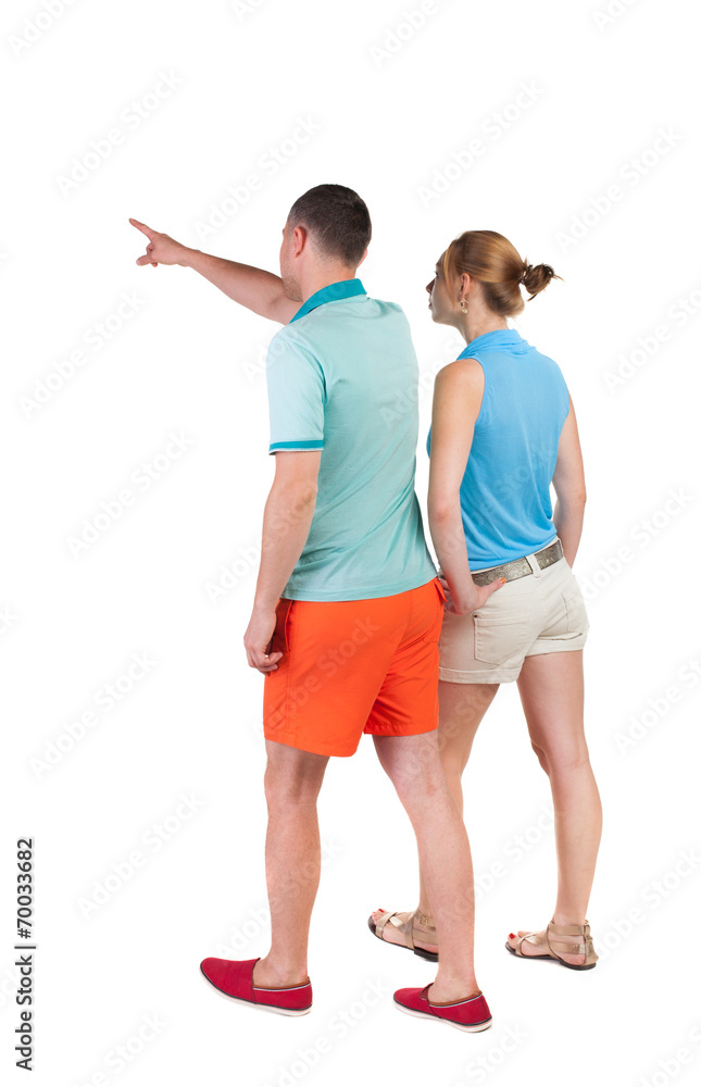 Back view of walking young couple (man and woman) pointing. Back view of walking young couple (man and woman) pointing.