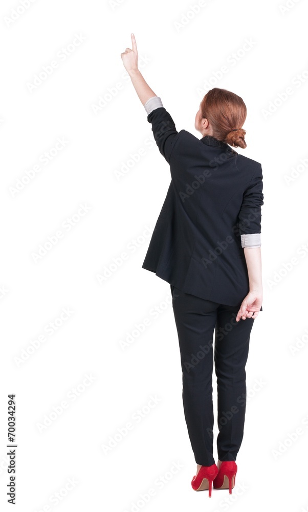 Back view of young redhead business woman pointing at wal Back view of young redhead business woman pointing at wal