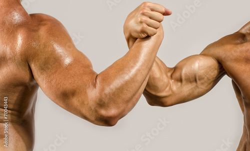 Strong bodybuilders testing their biceps in a skandemberg contes