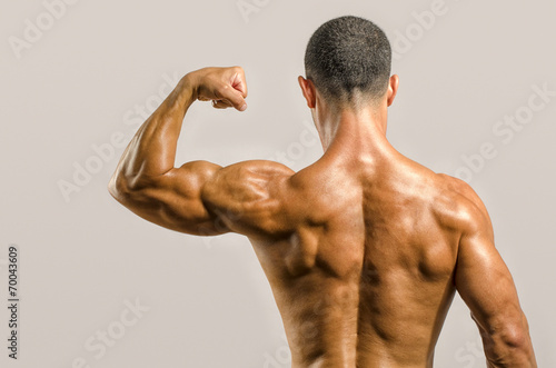 Bodybuilder showing his back and biceps muscles, fitness trainer