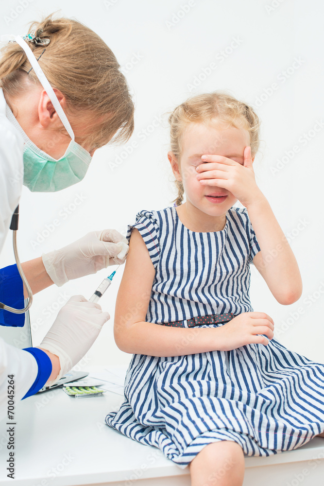 Fototapeta premium Female doctor doing vaccine to little girl.