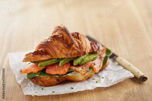 Butter croissant with avocado and salmon
