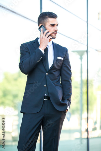 elegant man talking at cellphone on the street