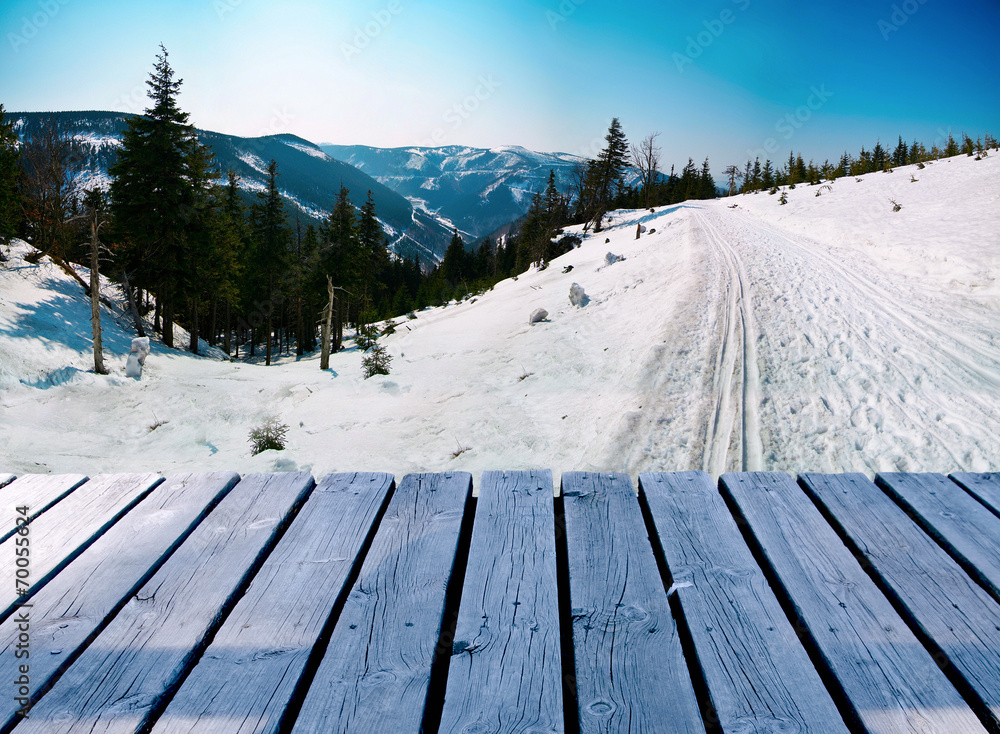 Wooden balcony on winter landscape with skiing path Wooden balcony on winter landscape with skiing path