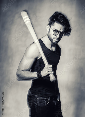 sexy fashion man model with a baseball bat looking angry