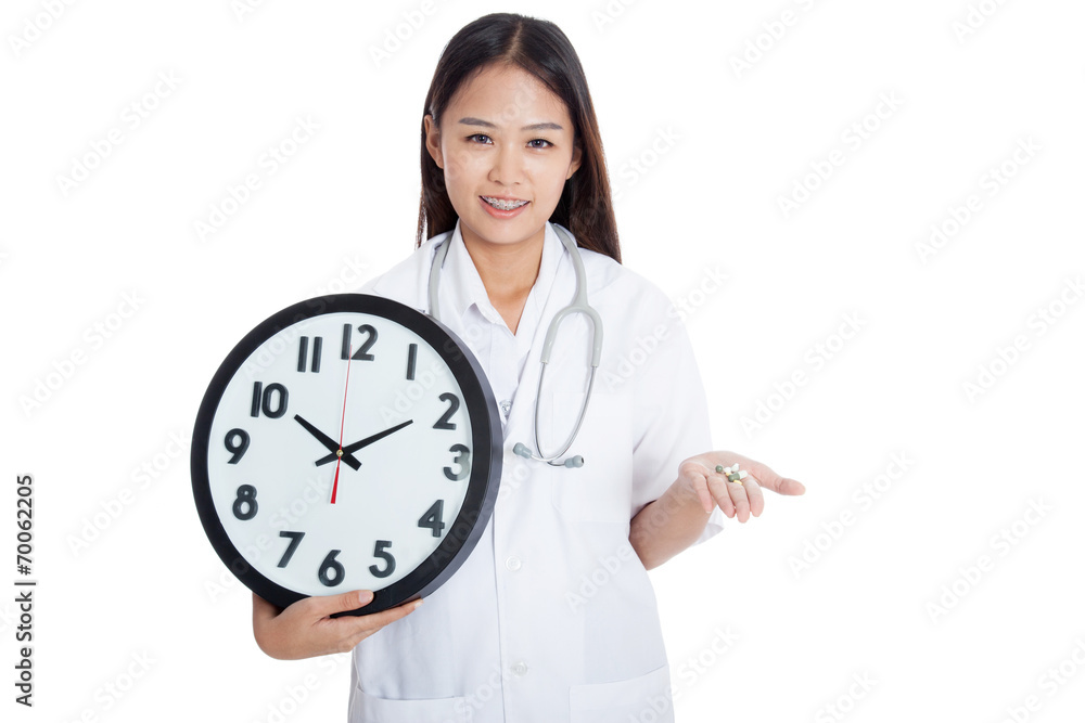 Young Asian female doctor smile with a clock and pills in hand Young Asian female doctor smile with a clock and pills in hand