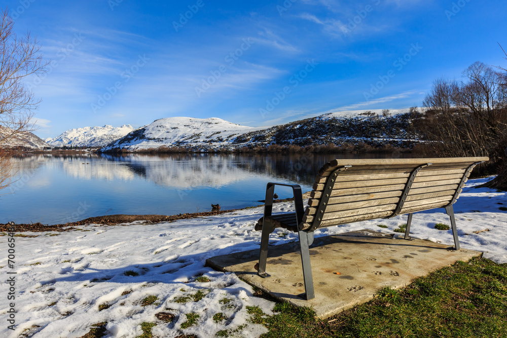 lonely bench in winter with lake view