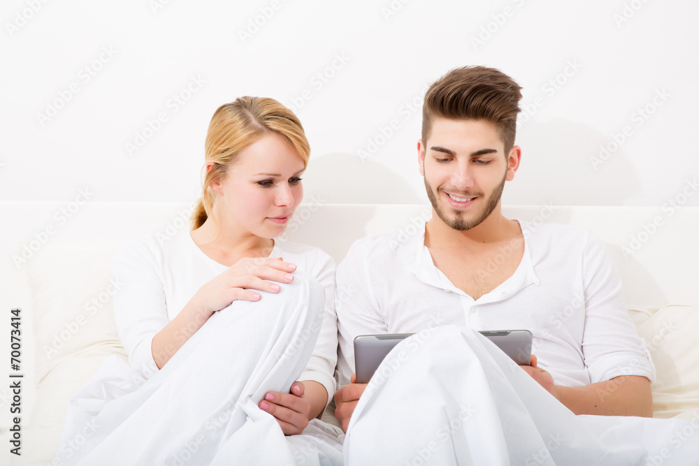 Glückliches Pärchen mit Tablet Pc im Bett Glückliches Pärchen mit Tablet Pc im Bett