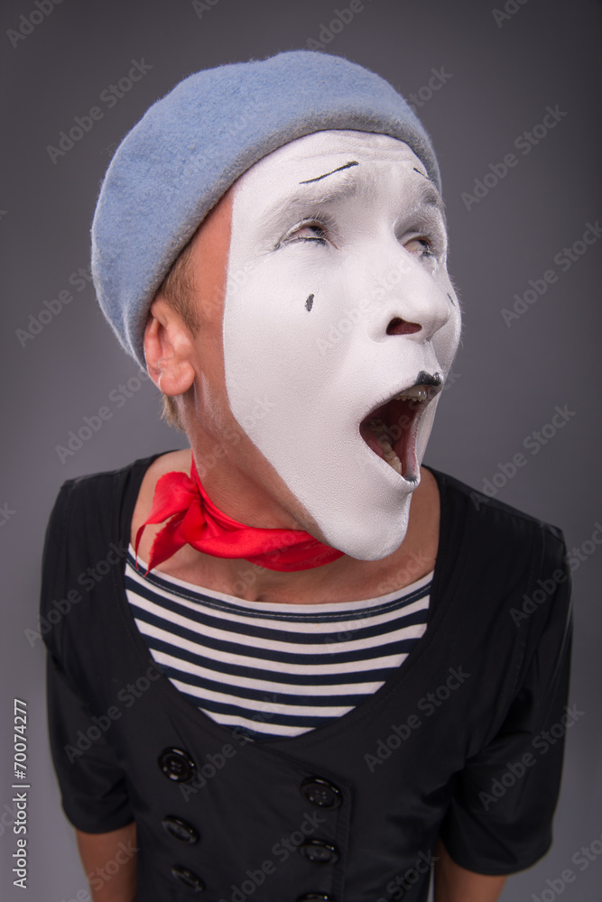 Portrait of male mime in red head and with white face isolated o Portrait of male mime in red head and with white face isolated o