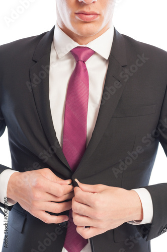 Business man closing his suit jacket.