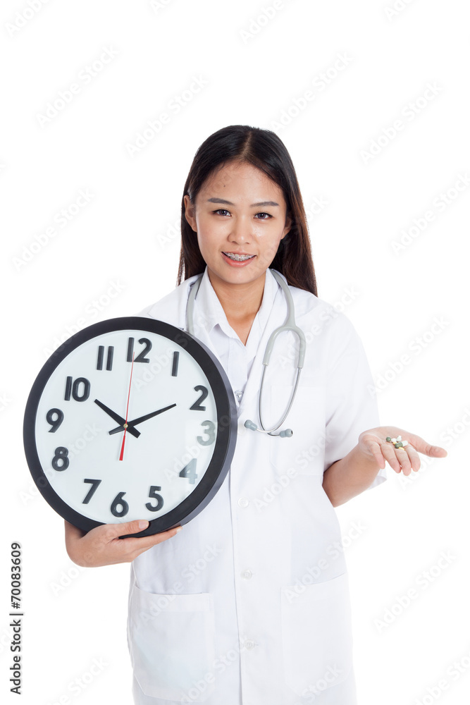 Young Asian female doctor smile with a clock and pills in hand Young Asian female doctor smile with a clock and pills in hand