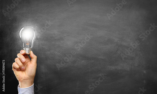 Hand holding Light Bulb / Blackboard