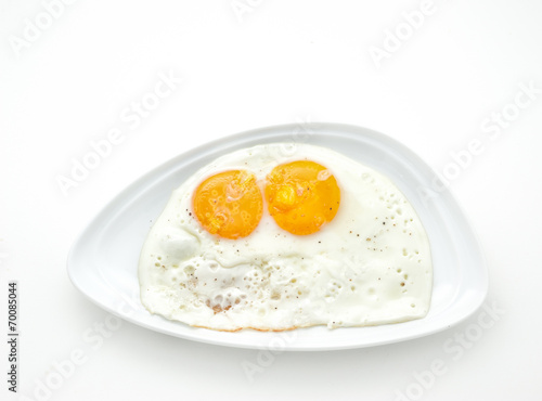 Two scrambled eggs on a white plate