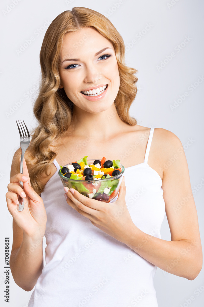 Woman with vegetarian salad, over gray Woman with vegetarian salad, over gray