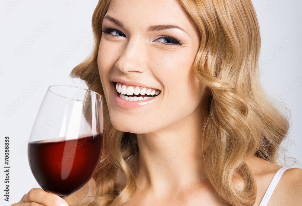 Young happy woman with glass of red wine, on gray Young happy woman with glass of red wine, on gray