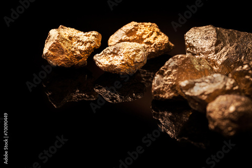 Gold nuggets on black background. © REDPIXEL