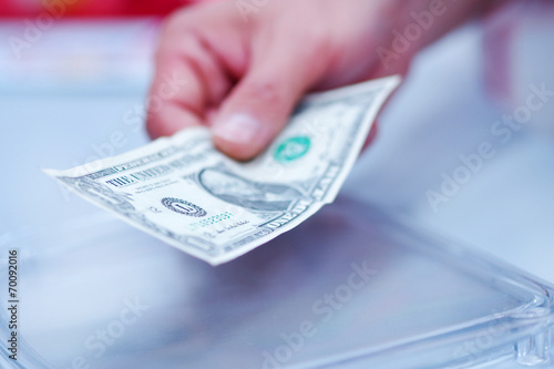 Man paying with money in the shop.