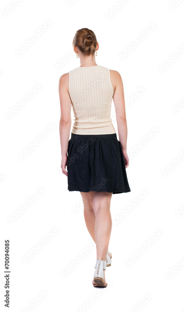 back view of walking  woman in dress. beautiful blonde girl in m