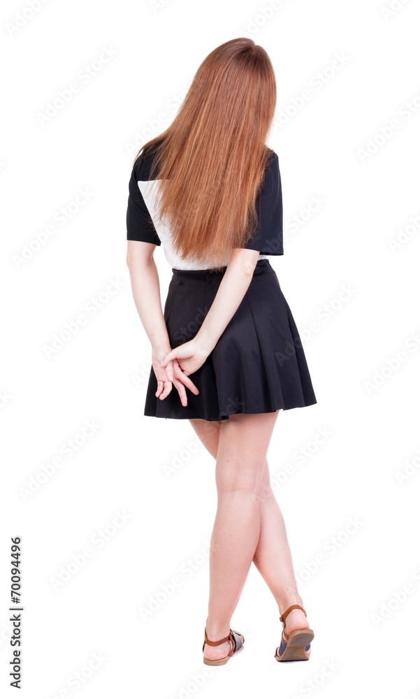 Back view of young redhead woman pointing at wall. Back view of young redhead woman pointing at wall.