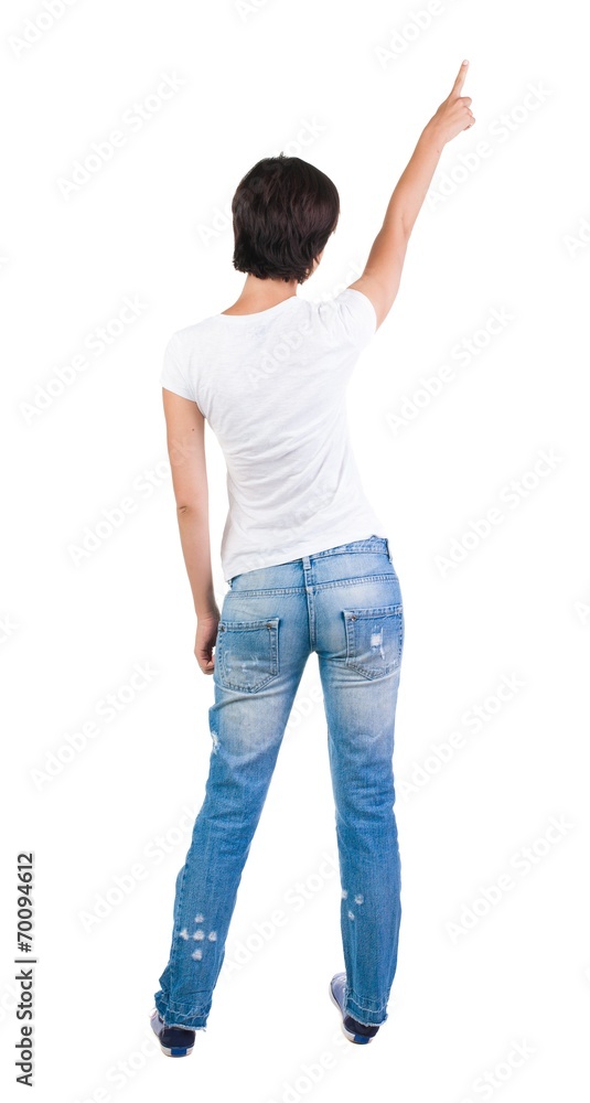 Back view of young brunette woman pointing at wall. beautiful gi Back view of young brunette woman pointing at wall. beautiful gi