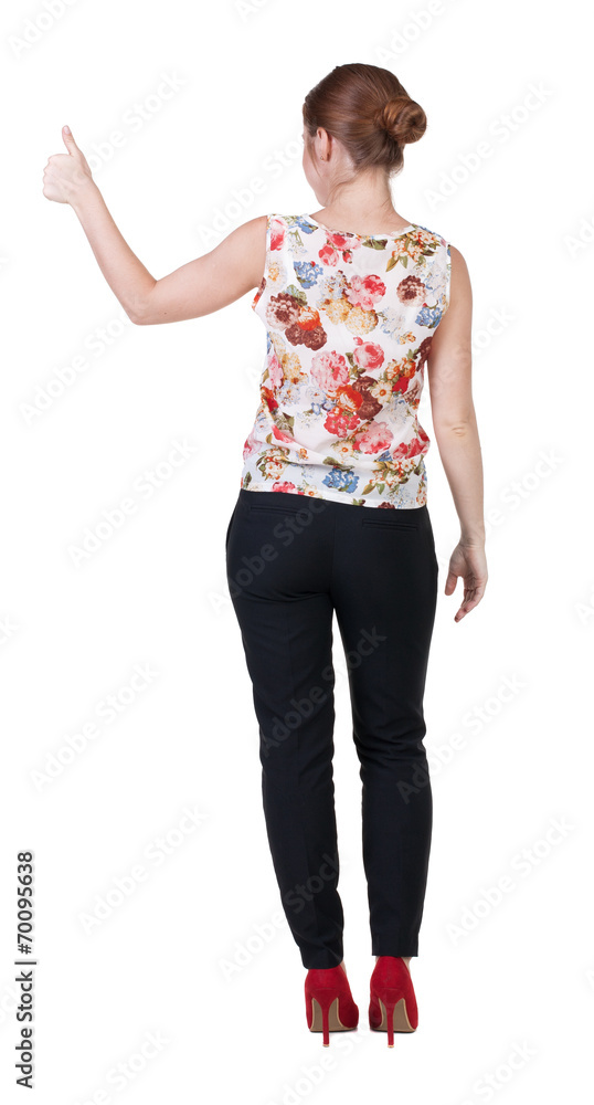back view of standing young redhead business woman showing thumb back view of standing young redhead business woman showing thumb