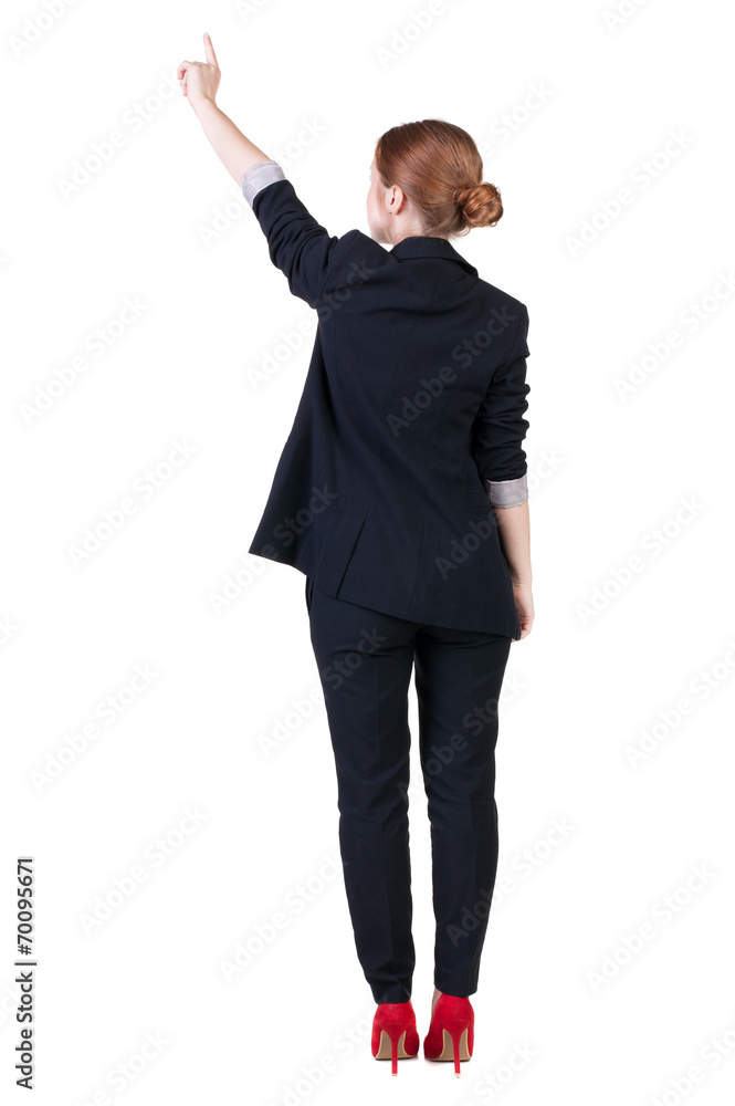 Back view of young redhead business woman pointing at wal