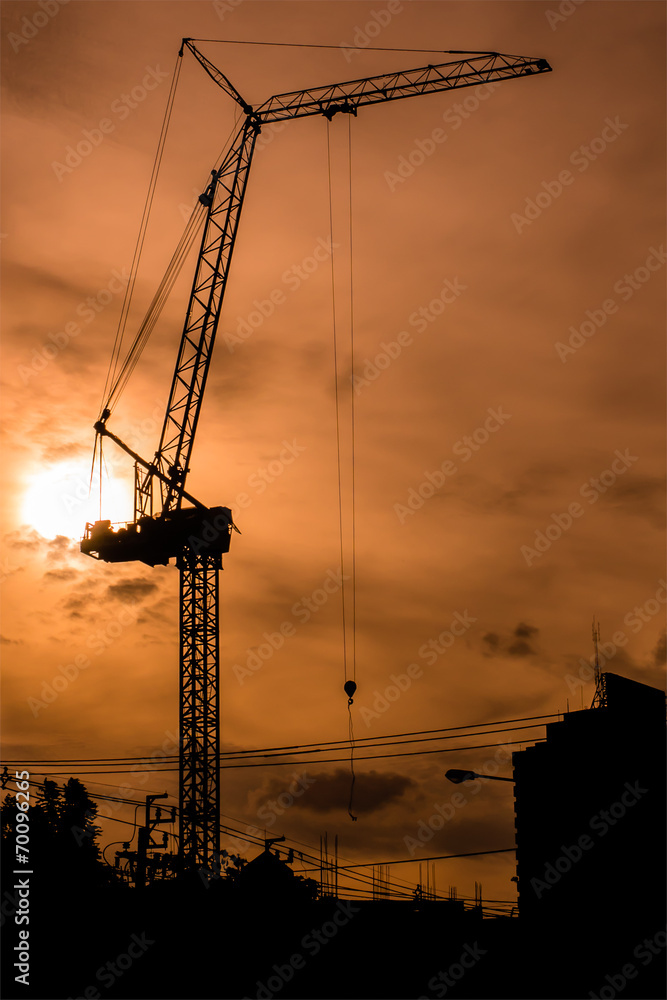Silhouetted construction crane in the evening