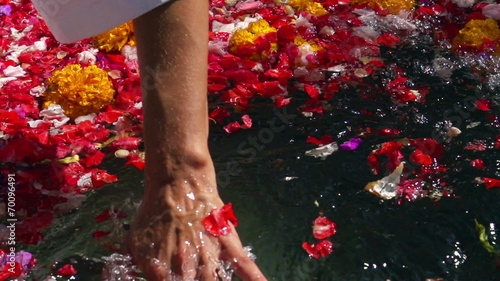 Woman checking water in bath of flowers, slow motion 240fps