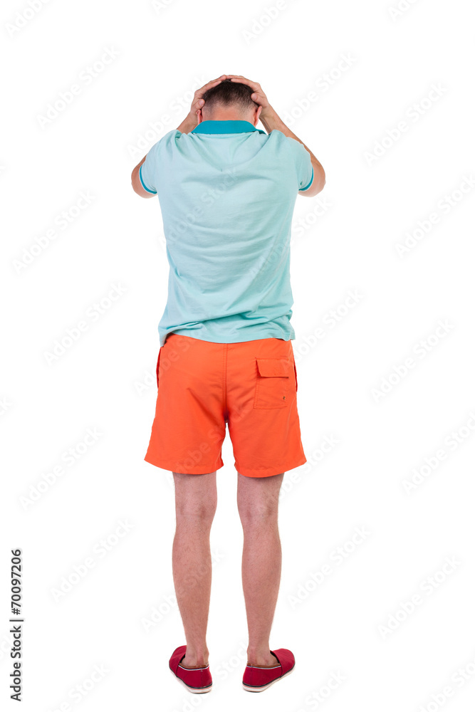 Back view of angry young man in shorts and t-shirt.