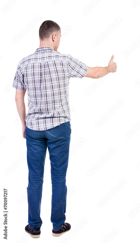 Back view of man in checkered shirt shows thumbs up. Back view of man in checkered shirt shows thumbs up.