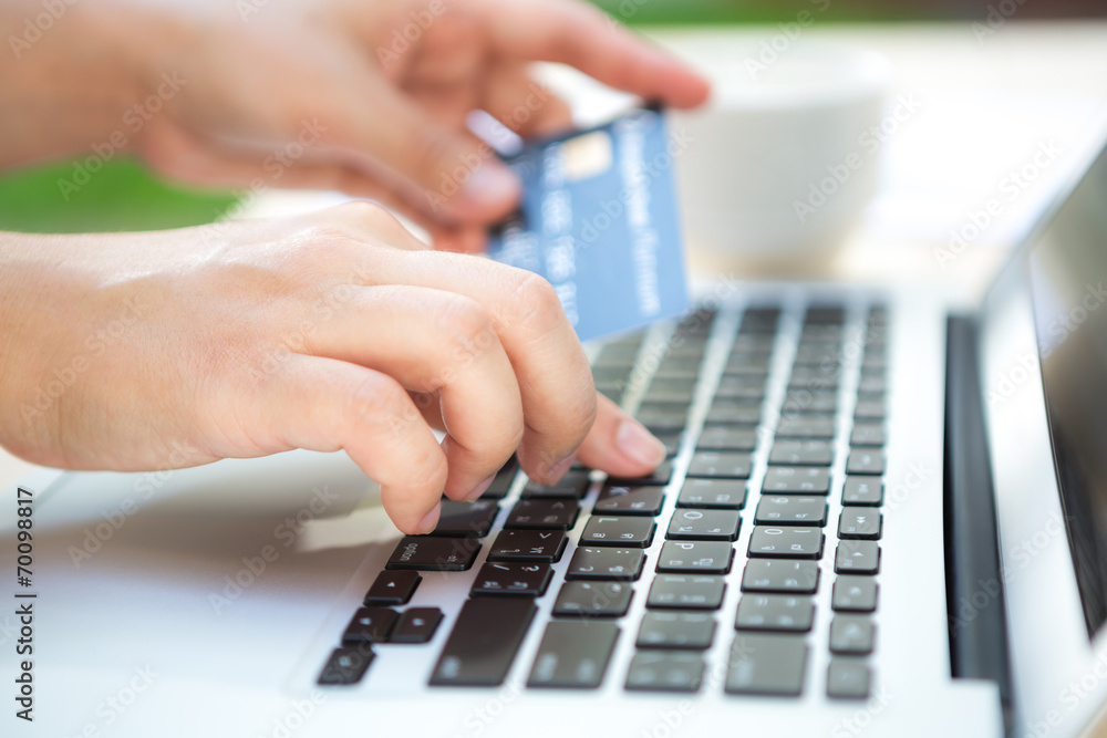 Hands holding a credit card and using laptop computer for online Hands holding a credit card and using laptop computer for online