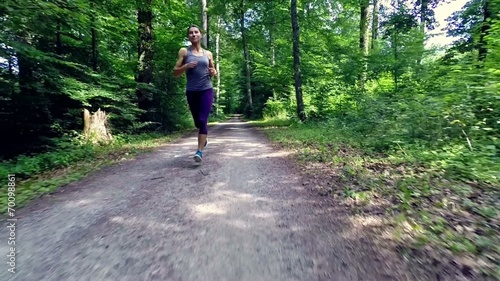 young woman jogging through forest