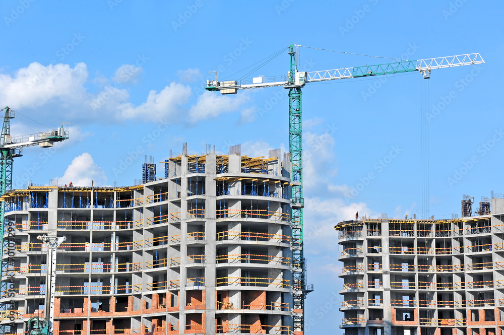 Crane and building construction site against blue sky