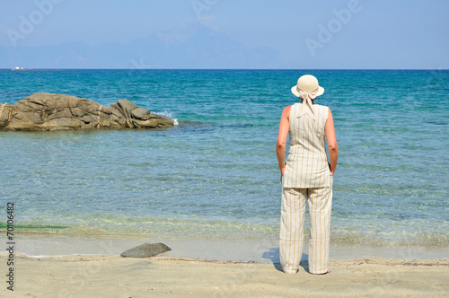 Woman wearing a hat standing on the sandy beach