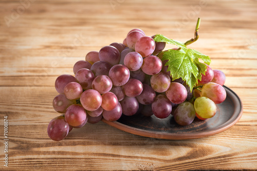 Tasty grapes on a background of a wooden table.