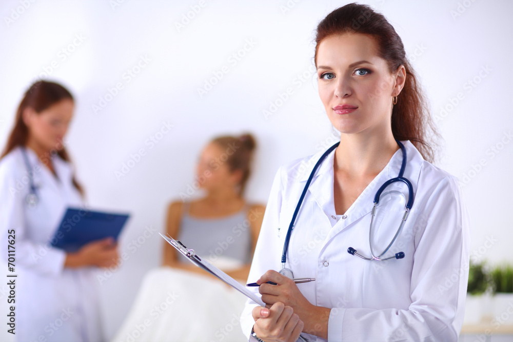 Smiling female doctor with a folder in uniform standing at hosp Smiling female doctor with a folder in uniform standing at hosp