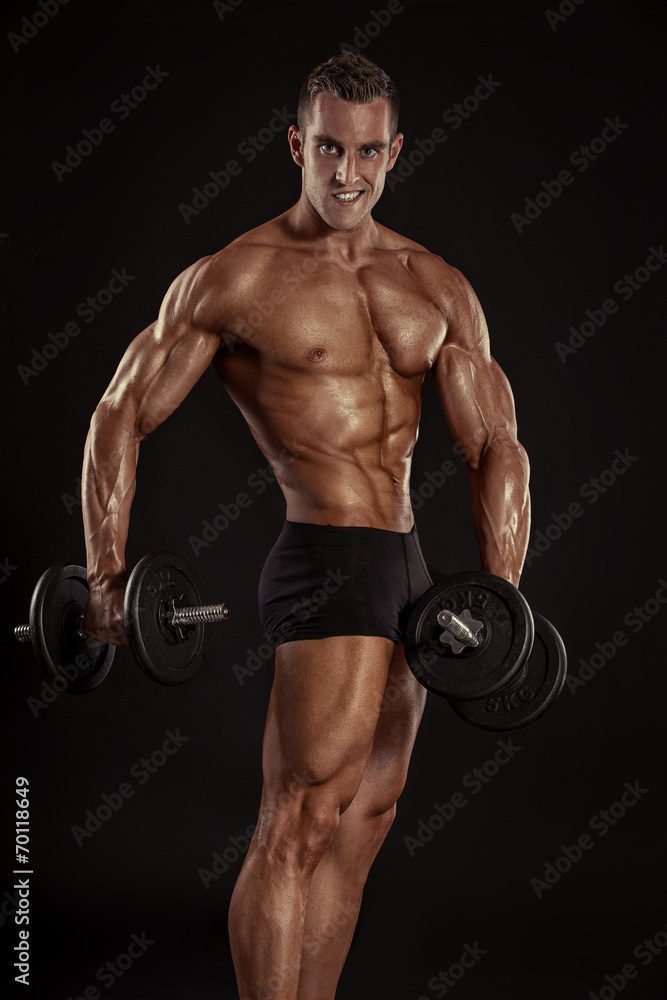 Muscular bodybuilder guy doing exercises with dumbbells