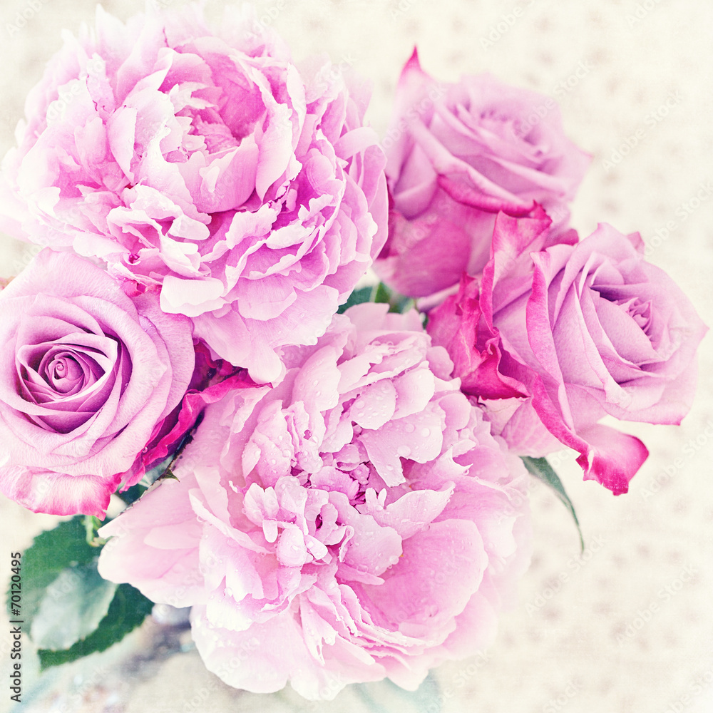 Close-up floral composition with a pink peony and roses .
