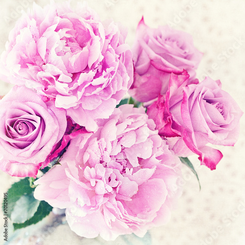 Close-up floral composition with a pink peony and roses .