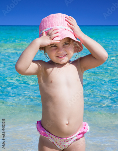 Bambina al mare con cappello rosa