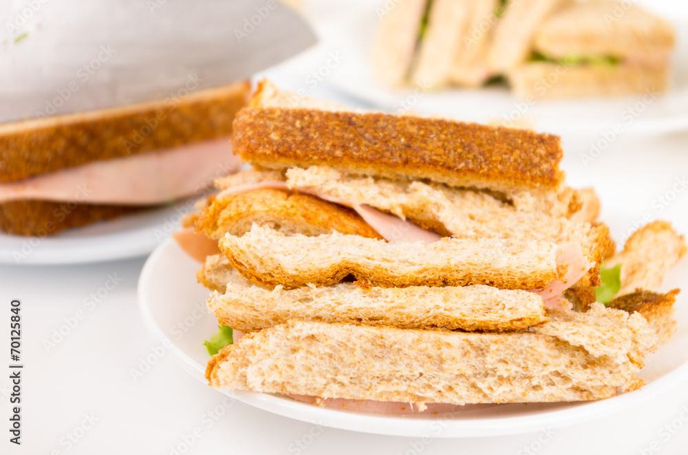 ham and lettuce sandwich on a white plate