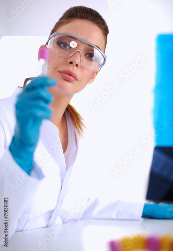 Woman researcher is surrounded by medical vials and flasks  iso