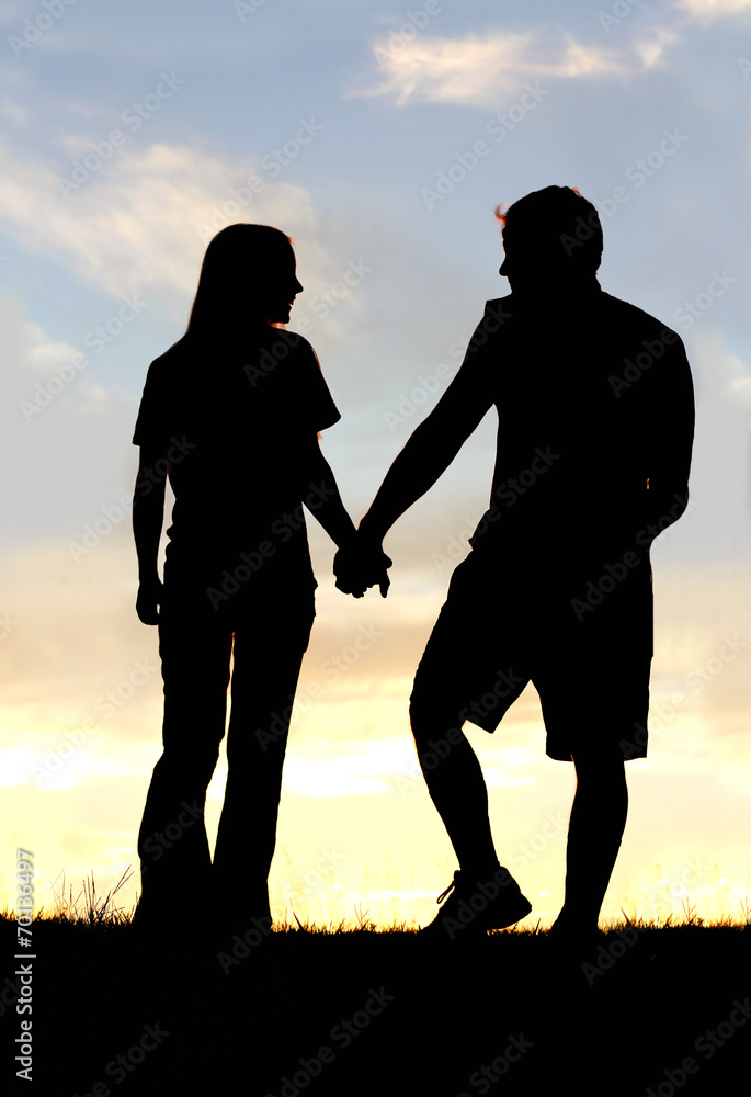 Silhouette of Happy Couple Holding Hands on Walk at Sunset