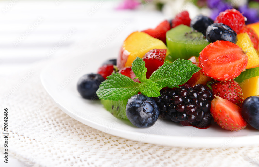 Delicious fruits salad in plate on table close-up Delicious fruits salad in plate on table close-up