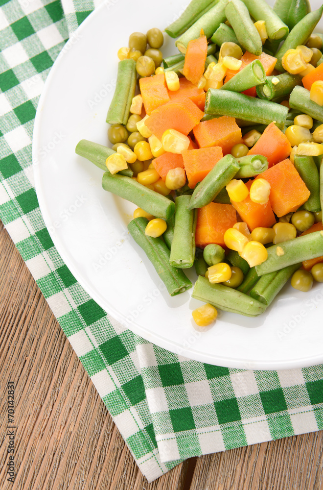 Delicious vegetables salad on plate on table close-up