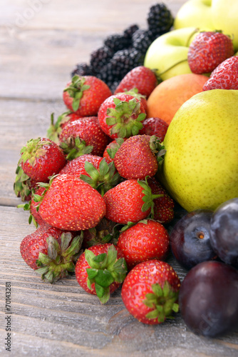 Ripe fruits and berries on wooden background