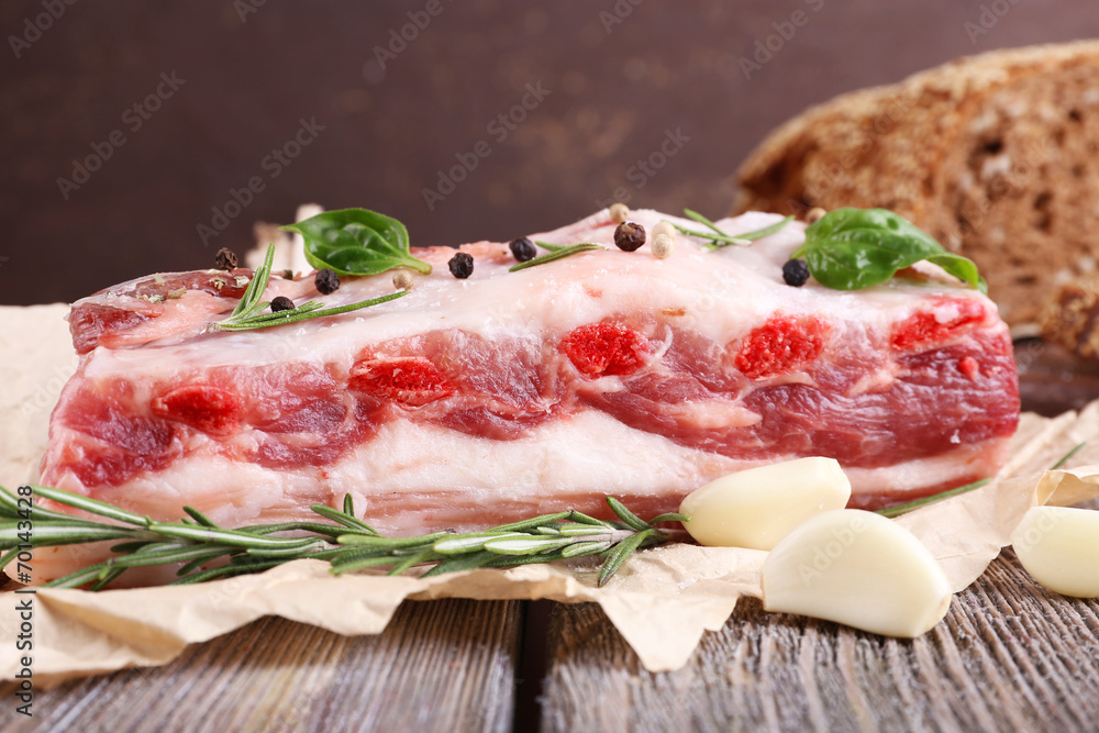 raw bacon with bread and spices on wooden table raw bacon with bread and spices on wooden table