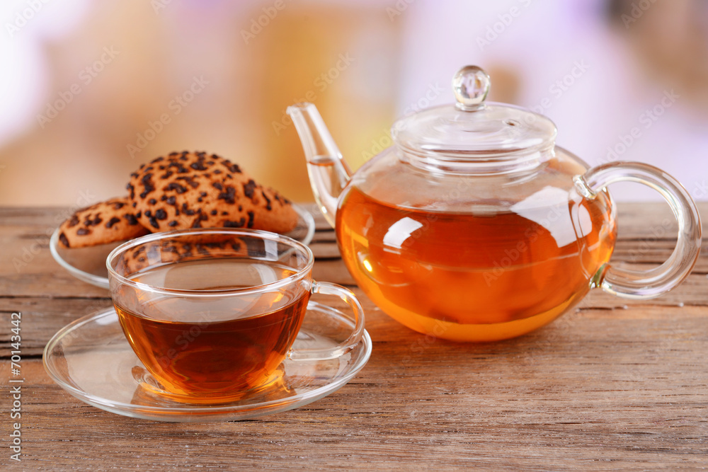 Teapot and cup of tea on table on light background Teapot and cup of tea on table on light background