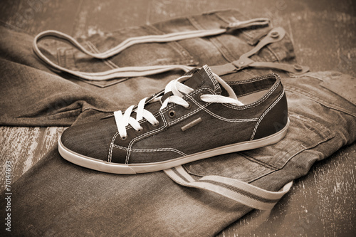 Black Sneakers and jeans with suspenders, Photo toning in sepia