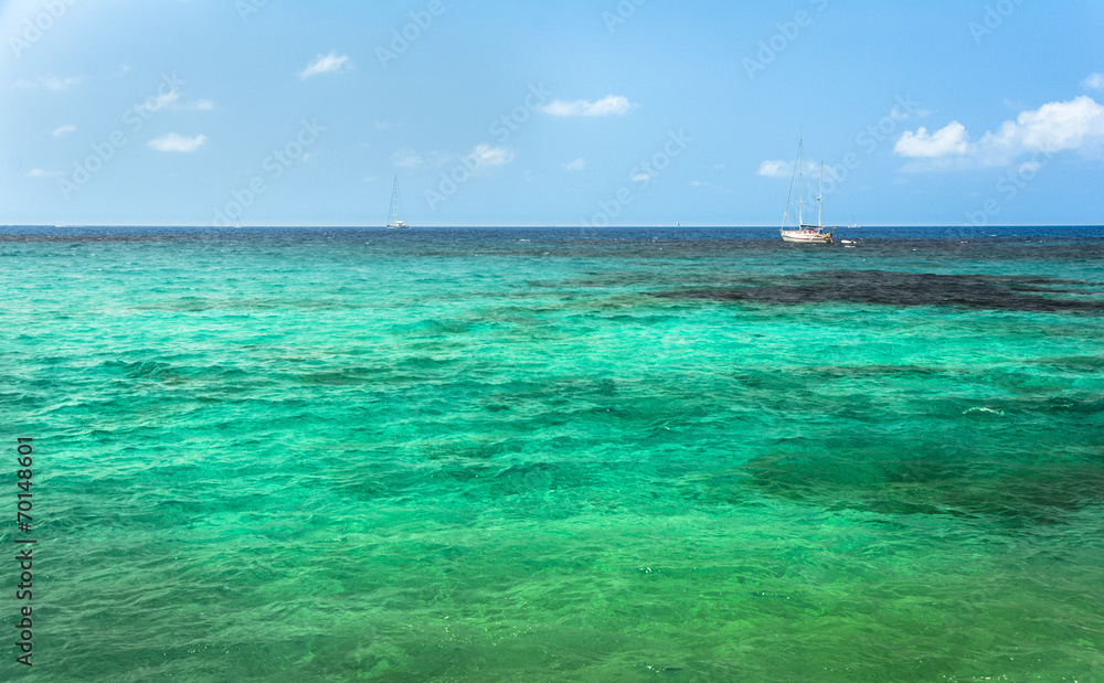 Sailing boat on turquoise mediterranean water in Ibiza island